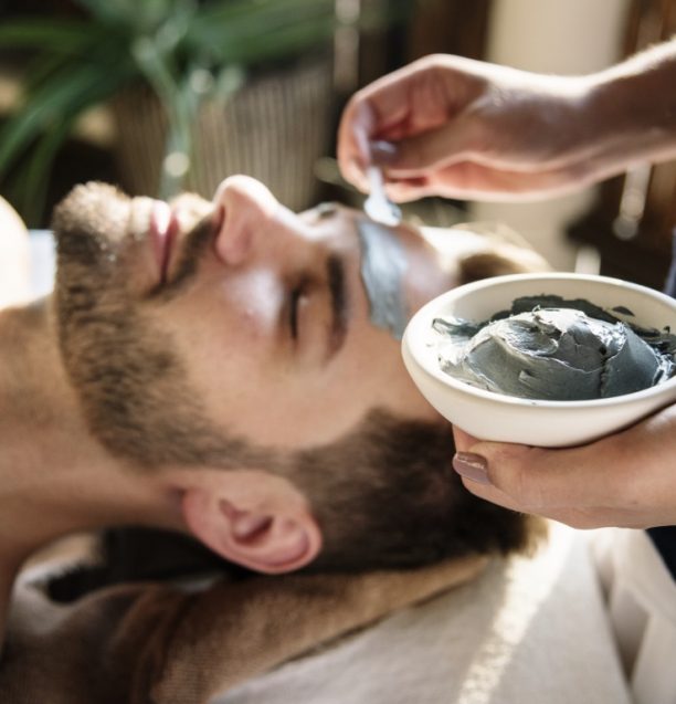 Man getting a mud mask at a spa Man getting a mud mask at a spa