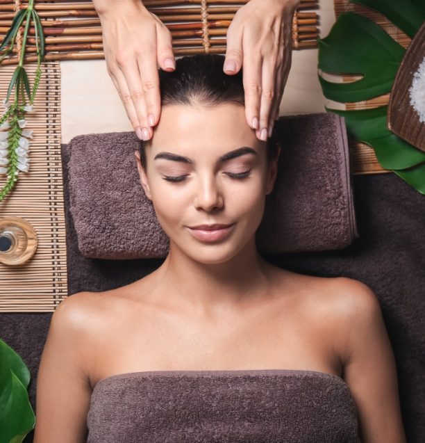 Beautiful young woman receiving massage in spa salon